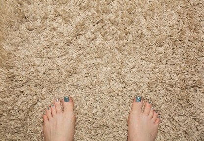 Woman standing on a beige bathmat