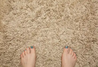 Woman standing on a beige bathmat