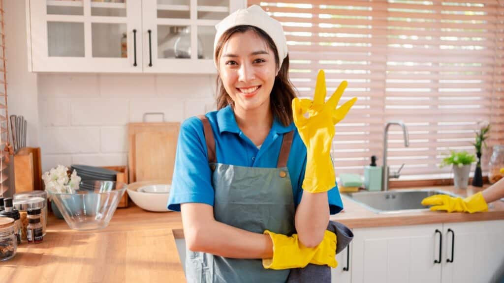 Professional maid service staff member ensuring high cleaning standards in a family kitchen.